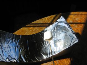 marshmallow being cooked using a solar cooker made from shoebox